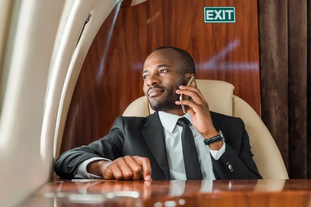 Businessman on a phone call aboard a private jet